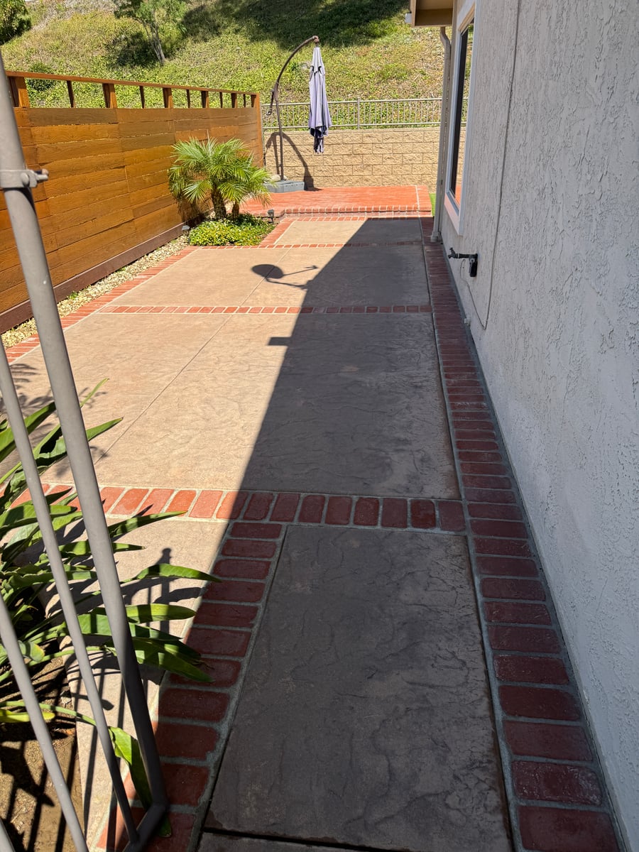 Pressure washing of concrete patio and brick bordered driveway